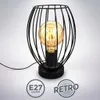 A black retro-style table lamp with a visible filament bulb, set against a light gray and white background. Produktbild-Vorschau