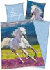 A white horse running through a field of purple flowers with a blue sky and mountains in the background. There are also two pillowcases with horse images and text. Produktbild-Vorschau