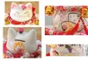 A collage of four close-up images of a Japanese Maneki-Neko porcelain cat figurine, showcasing different angles and decorative details. Podgląd zdjęcia produktu