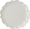 A white plate with embossed festive designs on the rim, shown from a top-down perspective. Voir les images du produit