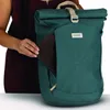 A person is holding a brown item and placing it into a teal backpack. Produktbild-Vorschau