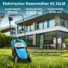 A blue electric lawnmower is shown in a grassy yard in front of a modern house with people in the background. Náhled obrázku produktu