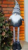 A decorative gnome figure is placed next to a Christmas tree. Náhled obrázku produktu
