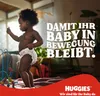 A baby wearing a diaper is standing and looking to the side, with text overlay and a brand logo at the bottom. Náhľad obrázku produktu