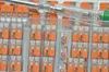 A close-up view of multiple packs of Wago lever connectors and a voltage tester. Produktbild-Vorschau