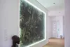 A hallway with a large, illuminated mural of a forest scene on the wall, and a white door at the end. Produktbild-Vorschau