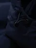 A close-up of a dark blue jacket's drawstring and toggle. Produktbild-Vorschau
