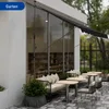 An outdoor seating area with a retractable awning, tables, chairs, and a sofa. Anteprima dell’immagine prodotto