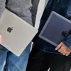 Two people holding MacBooks. Produktbild-Vorschau