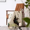 A decorative throw blanket draped over a chair in a room. Produktbild-Vorschau