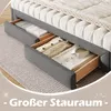 A bed frame with open drawers showing folded clothes and linens. Voir les images du produit