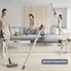 A woman is vacuuming a living room with a dog and a cat present. Another woman is vacuuming the ceiling. Produktbild-Vorschau