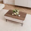 A coffee table with a floral arrangement and two small dishes on it, placed on a rug in a living room setting. Voir les images du produit