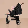 A baby sits in a black stroller against a plain background. Produktbild-Vorschau