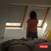 A woman stands in front of a skylight window with a roller blind. Produktbild-Vorschau