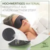 A woman wearing a sleep mask is lying in bed, with a close-up of the sleep mask material and its layers shown in the foreground. Anteprima dell’immagine prodotto