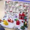 A child's hand points to a Paw Patrol advent calendar with various toys displayed in a winter scene. Podgląd zdjęcia produktu