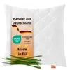 A white quilted pillow with a label showing product information and a small bunch of chives in the foreground. Produktbild-Vorschau