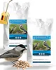 Two bags of birdseed with a bird and a pile of seeds in the foreground. Produktbild-Vorschau
