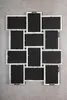 A collage of empty picture frames arranged on a gray concrete surface. Produktbild-Vorschau