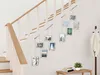A set of photo frames is displayed hanging on a wall next to a staircase. Podgląd zdjęcia produktu