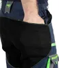 A close-up shot of a person's hand in the pocket of dark blue work pants with black and green accents. Produktbild-Vorschau