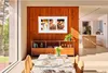 A living room with a TV on the wall, a dining table, and a kitchen in the background. Voir les images du produit