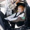 A baby is sitting in a car seat in a car. Anteprima dell’immagine prodotto