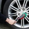 A person is cleaning a car wheel with a brush. Produktbild-Vorschau