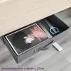 An open drawer under a desk, showing a magazine, scissors, and a ruler. Voir les images du produit