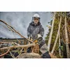 A person wearing protective gear is using a chainsaw to cut a tree branch. Voir les images du produit