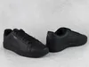 A pair of black Puma sneakers on a light gray textured surface. Produktbild-Vorschau