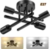 A black industrial-style ceiling light fixture with four arms, shown from a top-down perspective. Two smaller inset images show the light fixture installed in different settings, one with warm lighting and the other with cool lighting. Voir les images du produit
