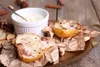 Baked pears with a creamy sauce and nuts on a rustic wooden table. Anteprima dell’immagine prodotto