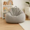 A light gray bean bag chair is placed in a child's room next to a white shelf with toys and a white nightstand. Produktbild-Vorschau