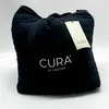 A black weighted blanket is folded and tied with a drawstring, with a tag attached. Podgląd zdjęcia produktu