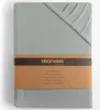 A folded fitted sheet with a branded paper band. Produktbild-Vorschau