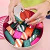 A person's hands holding a Sephora advent calendar, revealing the contents inside a large tin. Produktbild-Vorschau