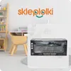 A toy RC tank is displayed in its packaging, placed in a child's room setting with a desk and shelf in the background. Anteprima dell’immagine prodotto