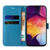 A blue flip phone case with floral and butterfly embossing, showing a phone with a colorful screen and a banknote inside. Produktbild-Vorschau