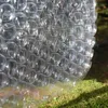 Bubble wrap is placed on mossy ground with sunlight filtering through trees. Produktbild-Vorschau