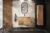 A modern bathroom with a wooden vanity, mirror, and cabinet, featuring a palm leaf wallpaper. Produktbild-Vorschau