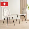 Two beige upholstered dining chairs with black metal legs are shown in a room with a light-colored wall and wooden paneling. Náhled obrázku produktu