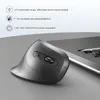 A vertical mouse is placed on a gray surface next to a laptop. Produktbild-Vorschau