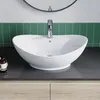 A white ceramic vessel sink with a chrome faucet is shown on a dark countertop, with green tiled backsplash and wooden cabinets below. Produktbild-Vorschau