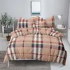 A neatly made bed with plaid bedding in a bedroom setting. Náhľad obrázku produktu