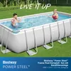 A couple is enjoying themselves in a rectangular above-ground swimming pool set up on a grassy lawn. Produktbild-Vorschau