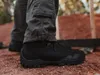 A person wearing black tactical pants and black boots standing on reddish-brown dirt. Produktbild-Vorschau
