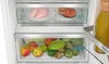 A close-up view of the interior of a refrigerator, showcasing various fresh food items stored in drawers. Produktbild-Vorschau