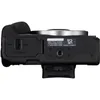 The bottom view of a black Canon EOS R50 camera, showing the battery and card compartment, and a tripod mount. Voir les images du produit